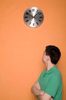 Side profile of a male office worker looking at a clock