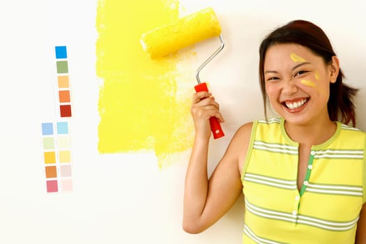 Portrait of a young woman holding a paint roller