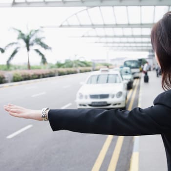 Rear view of a businesswoman hailing a taxi
