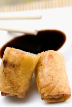 Close-up of spring rolls with a bowl of sauce