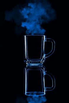 Just a glass on a black background with a reflection. Blue color, with steam. Isolated.
