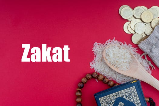 ZAKAT words with Holy Quran, Coins, Rosary and Rice. Zakat concept. Zakat is a form of alm-giving as a religious obligation