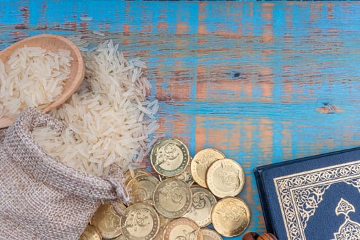 Holy Quran, Coins, Rosary and Rice. Zakat concept. Zakat is a form of alm-giving as a religious obligation