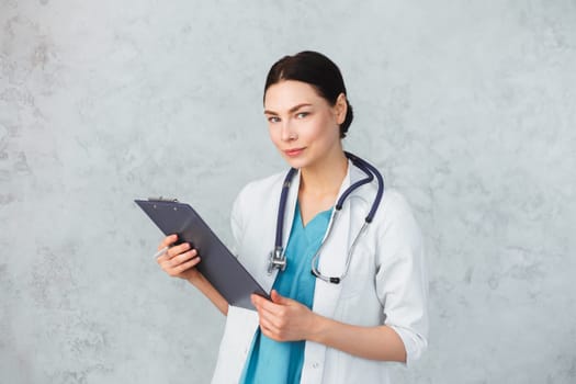 Young female doctor with stethoscope and folder. caucasian brunette.