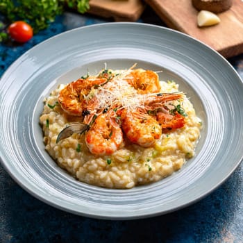 Risotto aux gambas features creamy Arborio rice topped with grilled prawns and garnished with colorful accents for an indulgent experience.