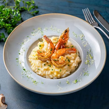 Risotto aux gambas features creamy Arborio rice topped with grilled prawns and garnished with colorful accents for an indulgent experience.