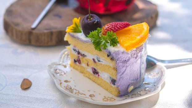 Close up Slice birthday fruit cake in plate violet delicious cream in layer