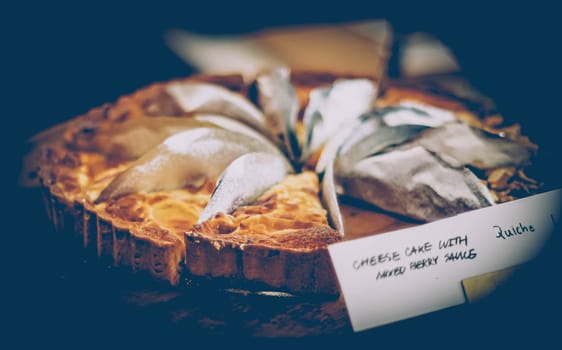 Close up view of cheesecake sliced on wooden plate in coffee shop. bakery food and drink business background idea