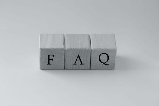 Color of the year Ultimate Gray. Wooden blocks with the word FAQ - frequently asked questions. Instructions and rules on Internet sites.