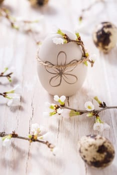 Easter eggs on with cherry branch. Easter decoration with quails eggs
