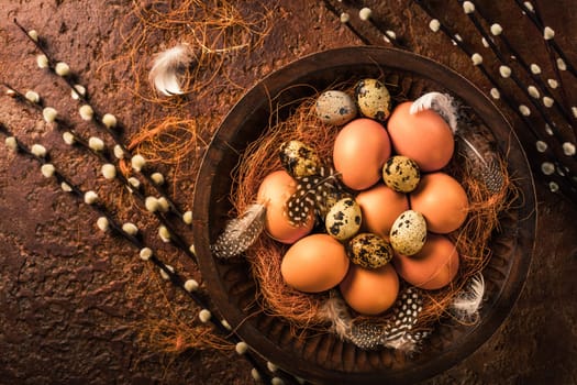 Eggs with pussy willow branches on rustic background. Easter table decoration.