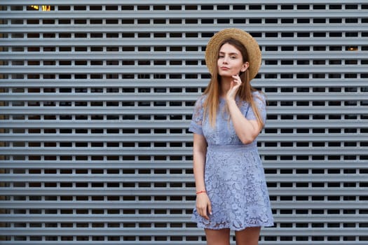 Portrait of a beautiful graceful woman in elegant hat and blue lace dress. Beauty, fashion concept.