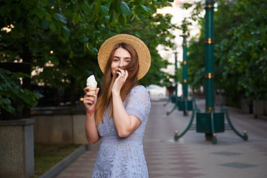 Young caucasian woman in summer hat enjoying the ice cream
