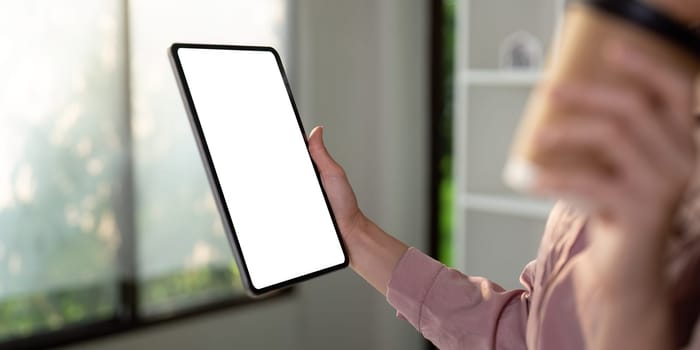 An individual presents a tablet in a well-lit room, showcasing the device for potential digital engagement.