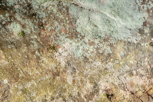 Even sandstone rocks with moss and lichen overgrown as background