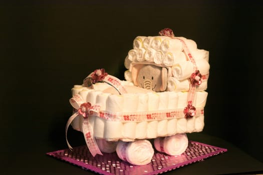 HEILIGENHAUS, NRW, GERMANY - JANUARY 16, 2019:.Newborn gift concept. Cake of diapers. Packed diapers as a stroller