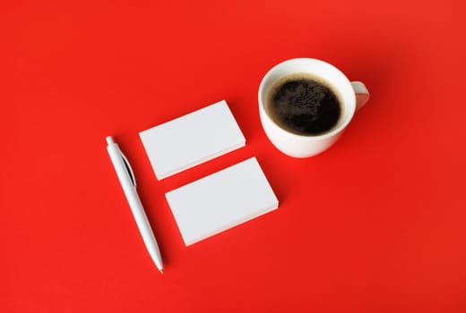 Blank stationery and corporate identity template on red paper background. Business cards, coffee cup and pen. Responsive design mockup.
