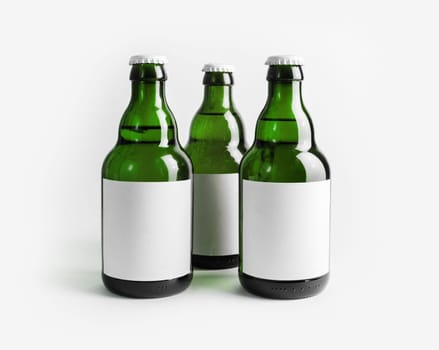 Three green beer bottles with blank labels.