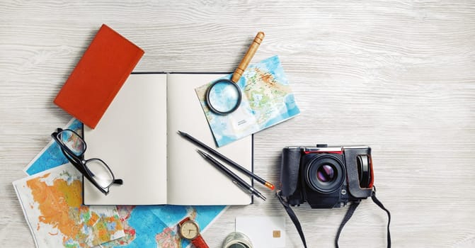 Vintage tourist devices. Traveler's accessories on light wooden background. Planning vacation. Flat lay.
