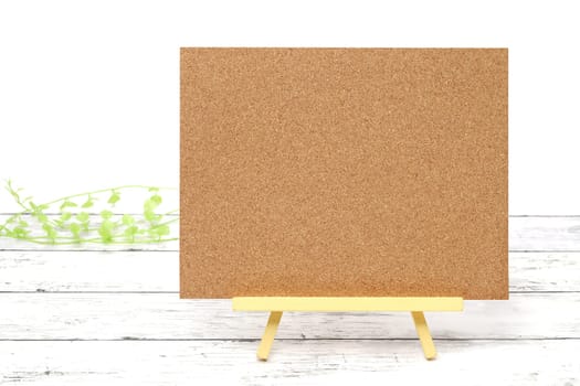 Wooden easel and blank board on a white wooden table