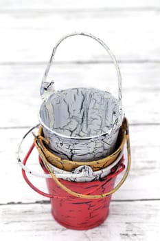 Empty miniature metal bucket on white wooden table