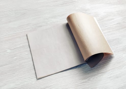 Blank magazine or brochure on wooden background.