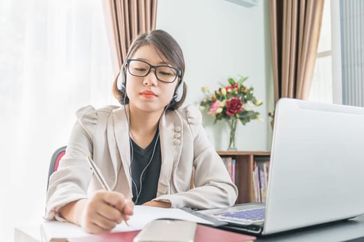 Teenage girl short hair in smart casual wear working on laptop while sit near window in home office
