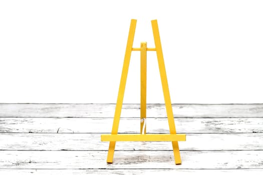 Wooden small easel on a white grunge wooden table