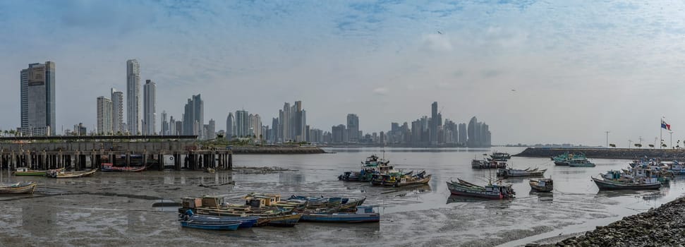 old fishing boats near fish market in panama city with skyline background