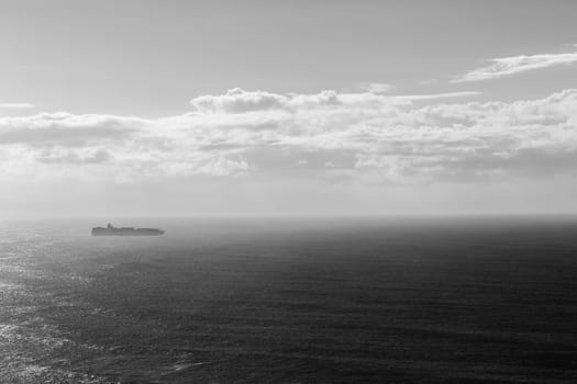 Ship travels open ocean seas overlooking birds-eye in black white vintage contrasts
