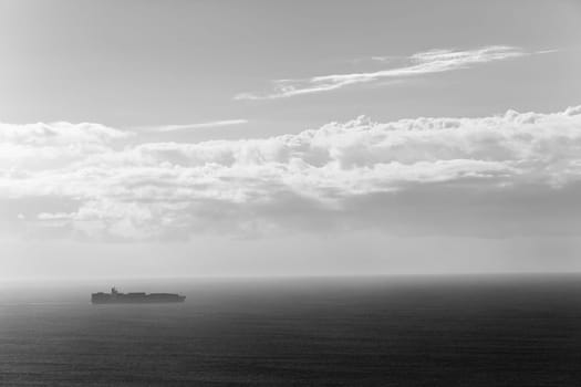 Ship travels open ocean seas overlooking birds-eye in black white vintage contrasts