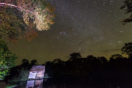Stars over the Amazon Rainforest with a small shack in the foreground near Iquitos, Peru