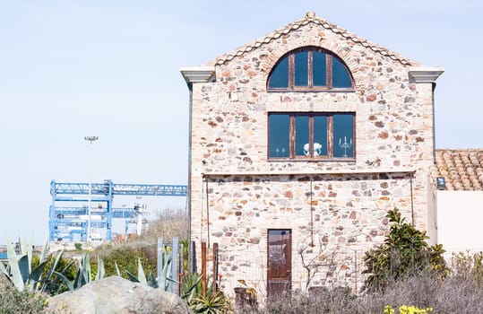 stone house and cranes near channel port in Cagliari
