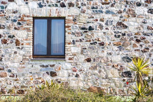 stone wall with window. particular of a stone house.