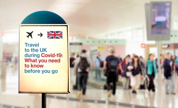 a signal inside an airport that warns about what to know before flying to England during the Covid-19 pandemic. Airport security measures and travel restrictions. Corona virus pandemic