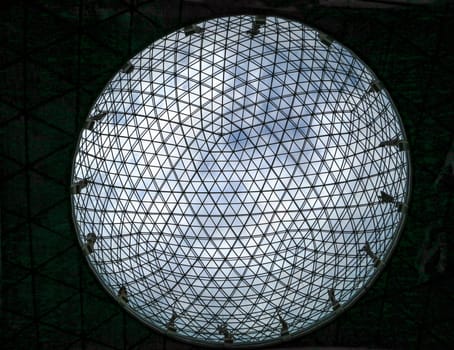 a round ceiling from glass and streel with the sky above
