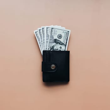 Bundle of dollars in purse on beige background. High quality photo