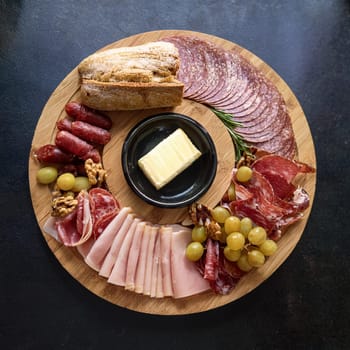 Assorted cured meats beautifully arranged with fresh baguette slices and creamy butter perfect for sharing and enjoying together.