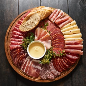 Assorted cured meats beautifully arranged with fresh baguette slices and creamy butter perfect for sharing and enjoying together.