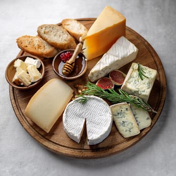 Artfully arranged selection of cheeses paired with fresh baguette slices and rich butter perfect for sharing and enjoying together.