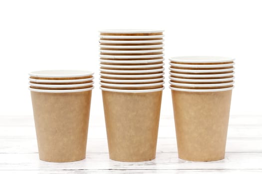 Empty disposable paper cup on white wooden table