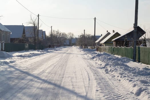 Winter rural road and trees in snow in village of Belarus
