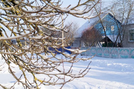 Snowy hills in russian or belarussian countryside in morning, wooden house