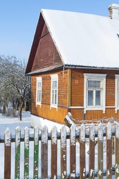 Vintage wooden rural house in Belarus, ornamental windows with carved frames. Russian traditional national folk style in architecture.