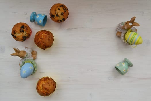 Easter eggs and sweet muffins top view, copy space