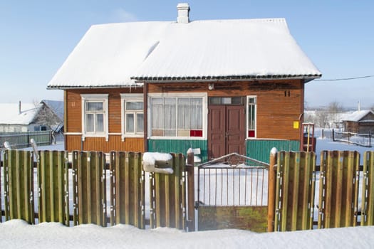 Traditional old log cabin covered with snow, winter sunny day il Belarus