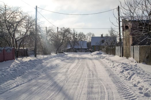 Long old village road covered with snow in Belarus