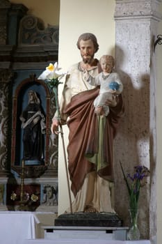 Saint Joseph holds a baby Jesus, a statue in the parish church of Our Lady of Mount Carmel in Bacva, Croatia
