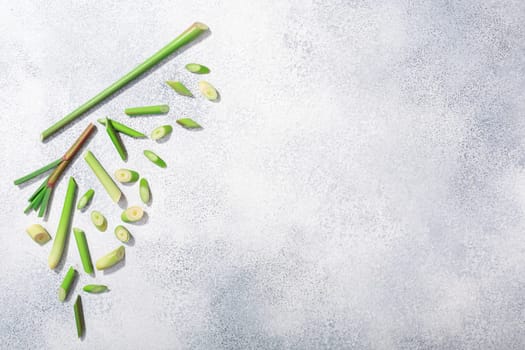 Lemongrass, cut stems atop grey textured backdrop w/ copy space, top view