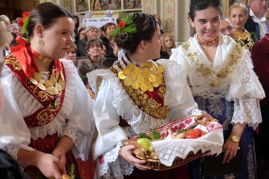 Women dressed in traditional regional folk costumes in the church at the Mass on Thanksgiving day in Stitar, Croatia